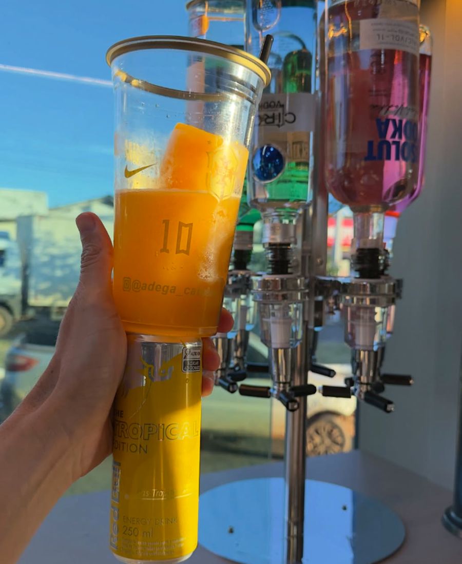 Drink servido em copo da Adega ao lado da torre dosadora de bebidas