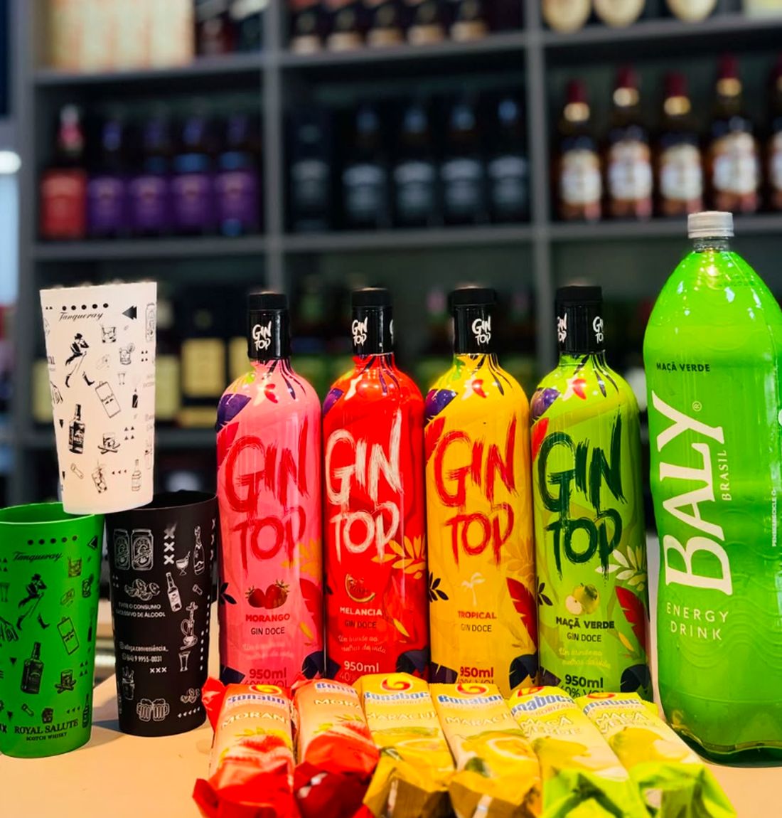 Garrafas de Gin Top coloridas, Baly maçã verde e copos da Adega sobre o balcão da loja